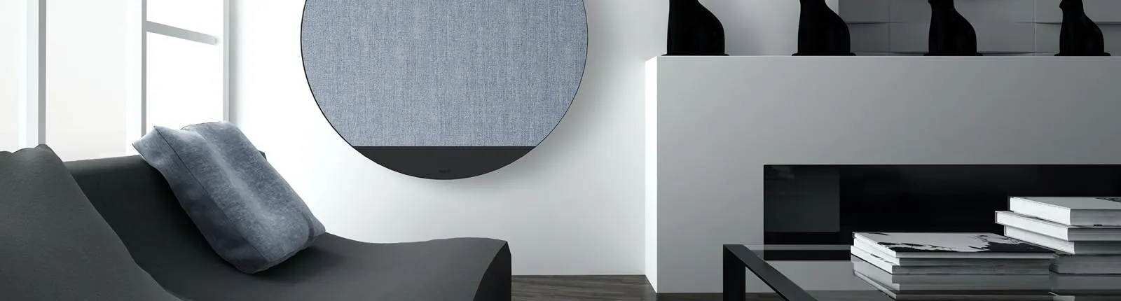 Ein modernes Wohnzimmer mit minimalistischer Einrichtung zeigt eine graue Couch mit einem blauen Kissen.