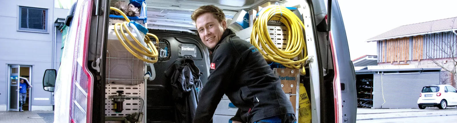 Kundendiensttechniker (SHK) vor Service-Fahrzeug.