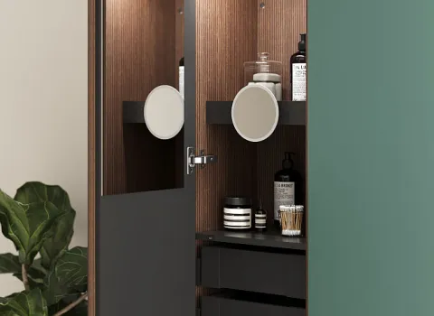Der Badezimmerschrank Burgbad Lin20 ist geöffnet und zeigt ein stilvolles Holzfurnier mit dunklen Regalen, die verschiedene Pflegeprodukte und einen runden Kosmetikspiegel halten.