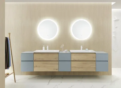 Ein großzügiges Doppelwaschtisch-Set in einem minimalistischen Badezimmer, bestehend aus zwei rechteckigen Waschbecken auf einer Kombination aus hellen Holz- und blauen Schubladen. 