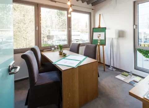 Heller Beratungsraum mit großem Tisch, Stühlen und Bauplänen für individuelle Badplanung bei bad & heizung Maier.