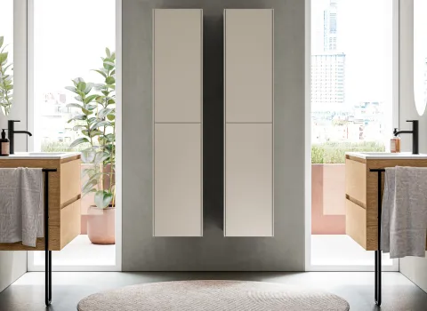 Symmetrische Badgestaltung mit zwei wandhängenden Waschtischen mit Holzfront, schwarzen Armaturen und hohen Fenstern in modernem Interior-Design von Stocco.