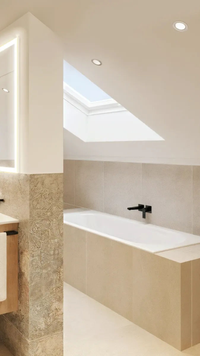 Ein modernes Badezimmer im Dachgeschoss mit einer eingebauten Badewanne unter einem großen Dachfenster. Die hellen Fliesen und das natürliche Licht schaffen eine ruhige Atmosphäre. Schwarze Armaturen setzen elegante Kontraste. Der Raum wirkt klar und harmonisch.