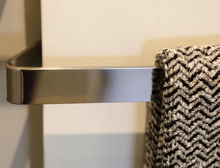 Detailaufnahme eines modernen Handtuchhalters aus Metall mit gemustertem Handtuch.