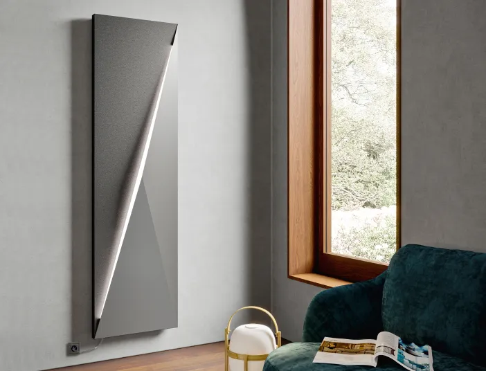Vertikaler Polygon-Designheizkörper vom Hersteller Bemm in Anthrazit mit LED-Beleuchtung in einem modernen Wohnzimmer.